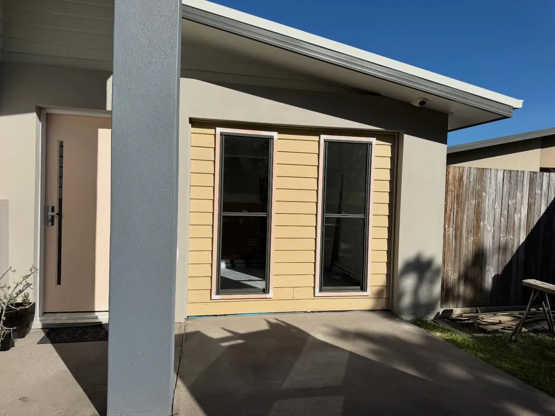 Single garage converted into a bedroom, with new cladding and two windows