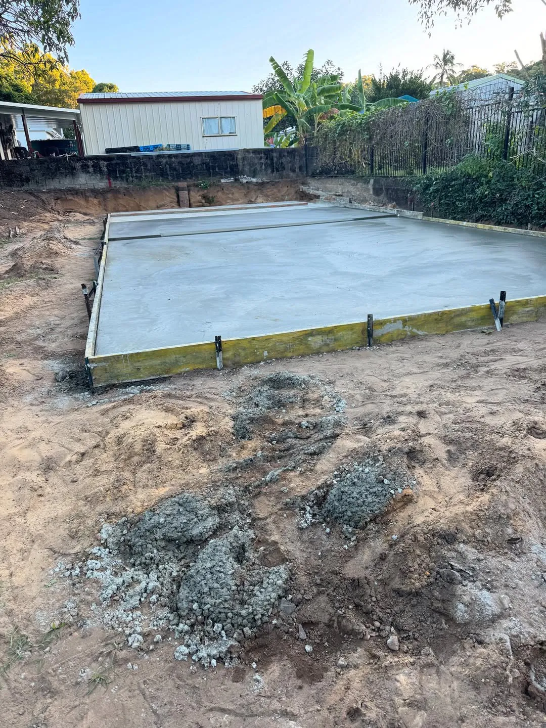 Freshly poured shed slab in a backyard